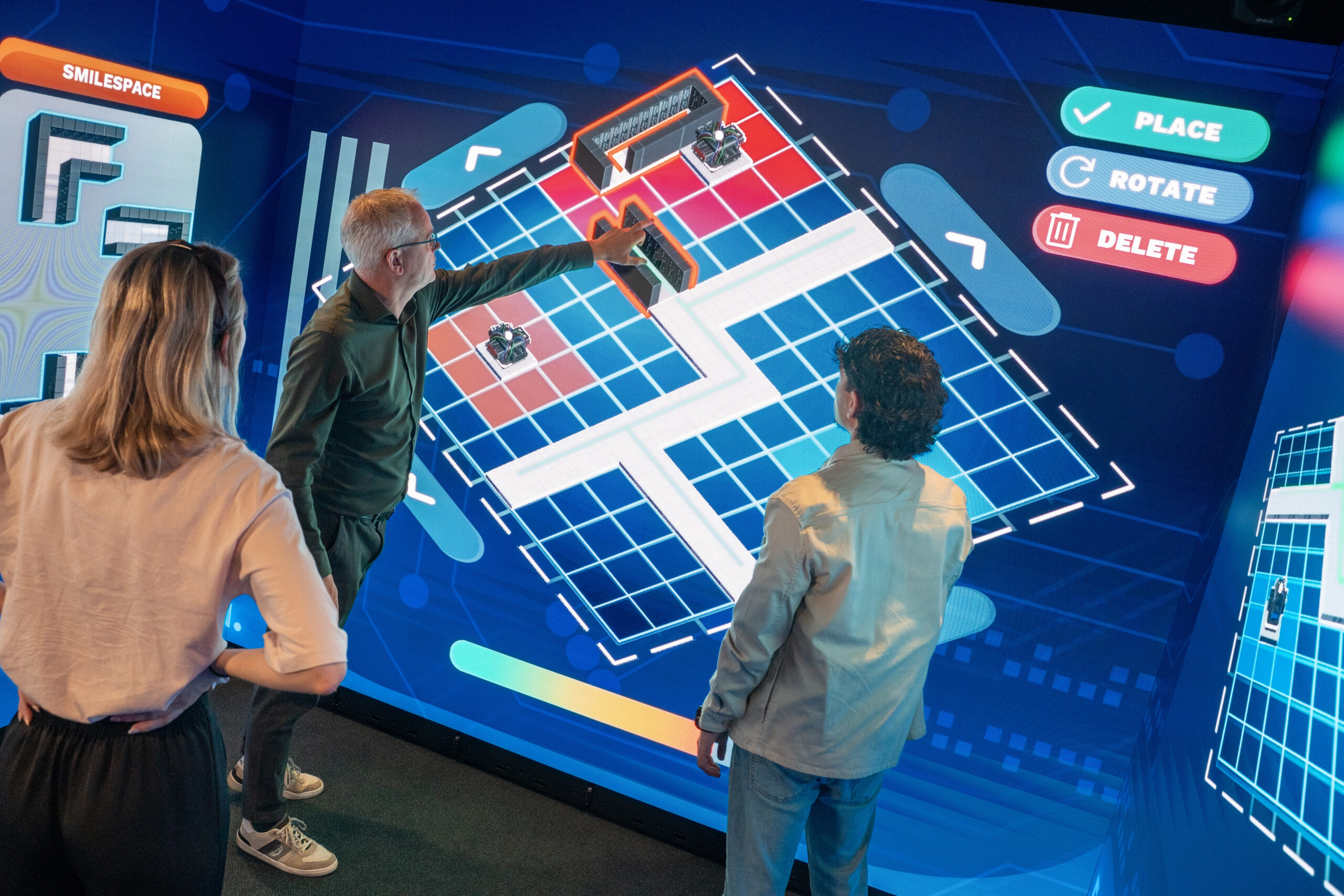 People collaborating with an interactive touchscreen application in an Immersive Room