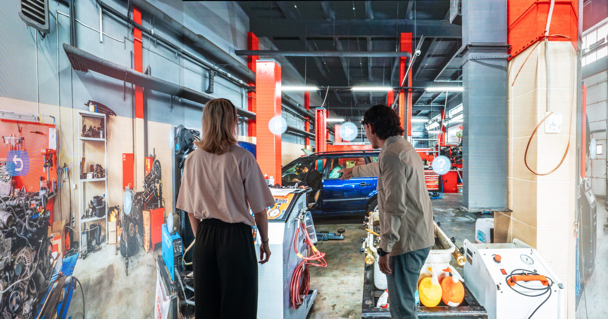 People exploring an interactive automotive workshop simulation inside an Immersive Room